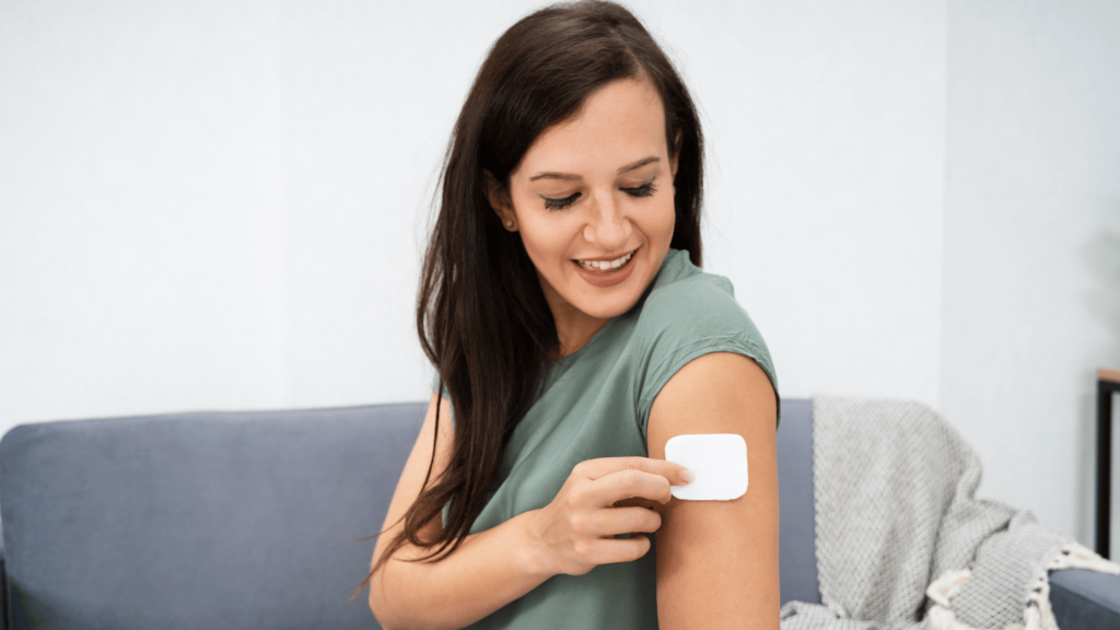 Woman applying what looks like a buprenorphine patch on arm