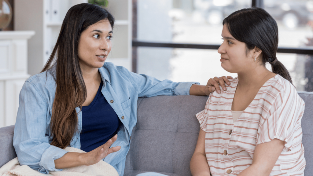 Woman supporting loved one while having an honest conversation about addiction on the couch discussing how to talk to someone about substance use and recovery