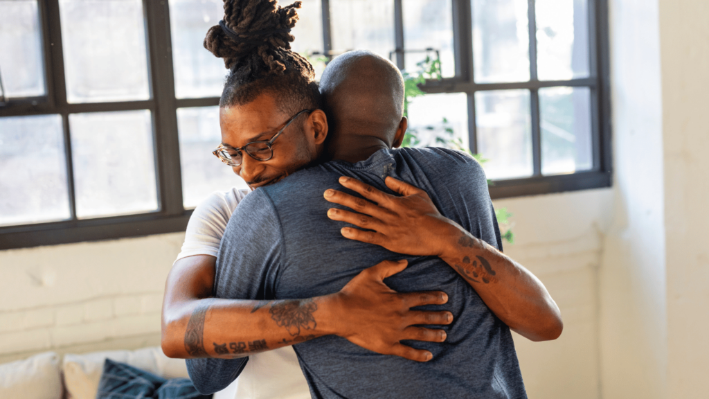 Two men embrace in a moment of emotional support, symbolizing connection, healing, and recovery from opioid addiction