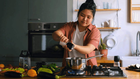 Person cooking a healthy meal at home with fresh vegetables, preparing food that supports weight loss and balanced nutrition on Ozempic or GLP-1 medications
