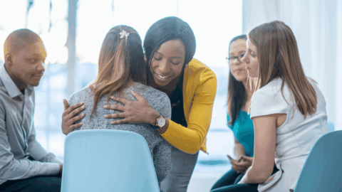 Woman embracing another woman in drug addiction therapy