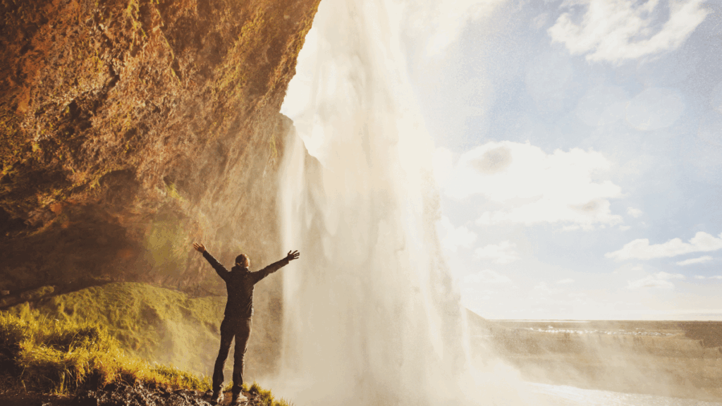 Woman standing at waterfall representing positive recovery from opioids