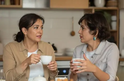 women talking about perimenopause and menopause in the kitchen drinking tea