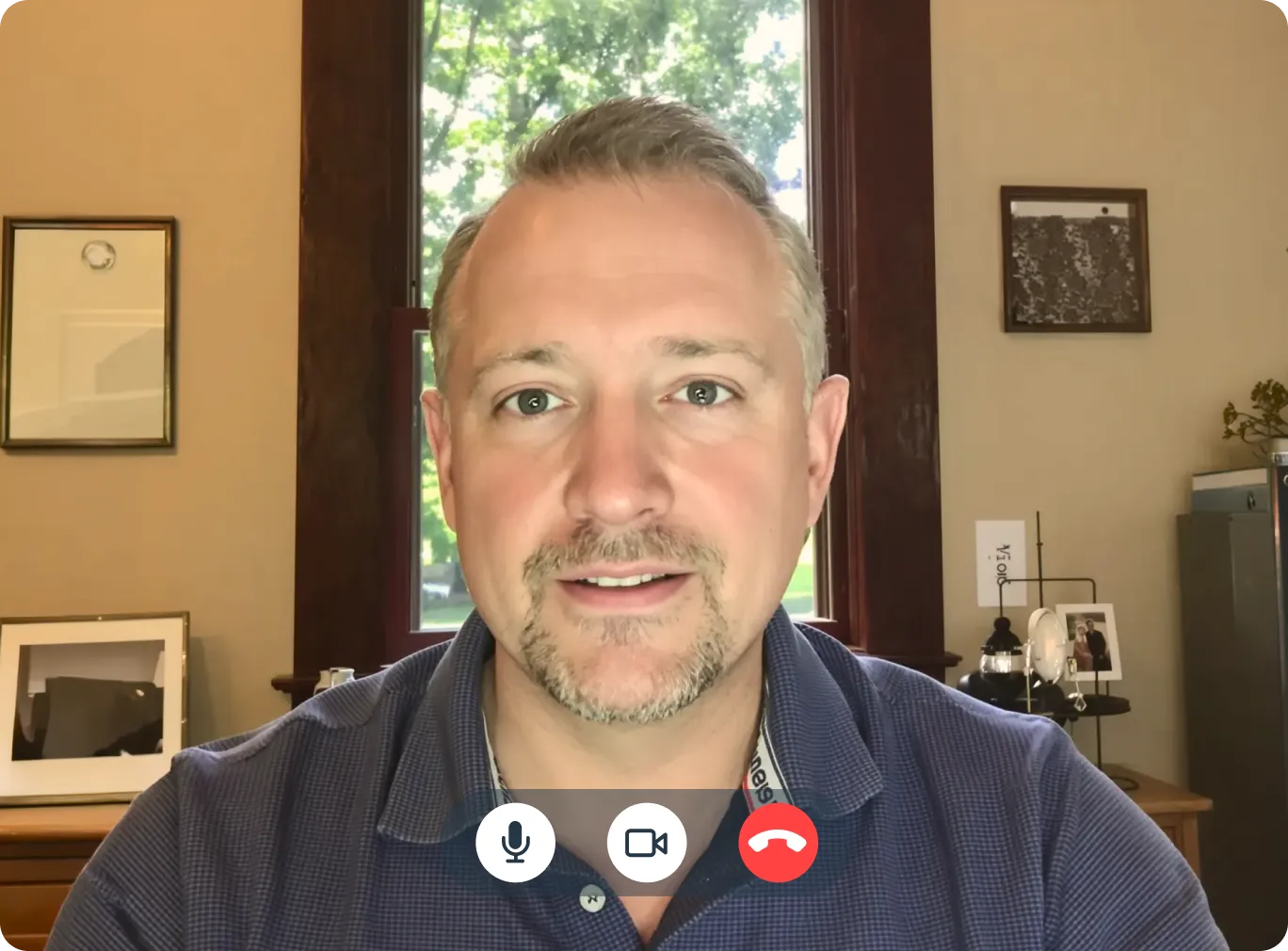 Man in Alabama having a telehealth video consultation with a doctor from home office with framed pictures on the wall