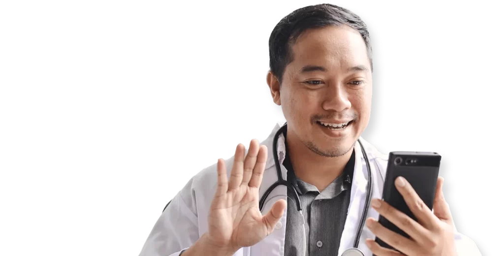 Smiling doctor in white coat with stethoscope waving during a telehealth video consultation on smartphone
