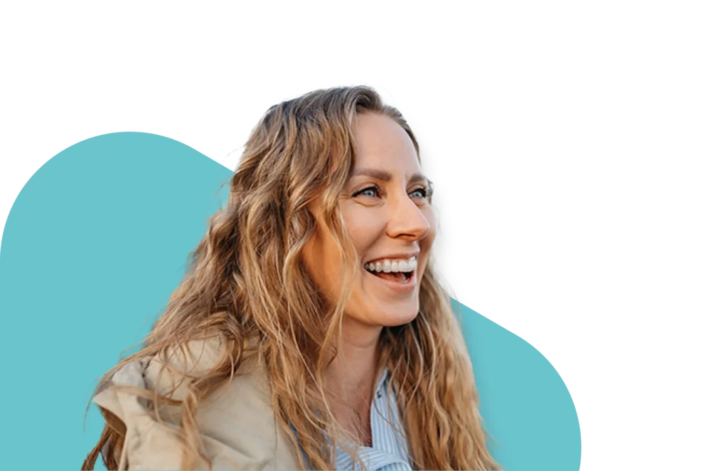 Smiling woman with long wavy blonde hair wearing a beige jacket, representing hope and recovery through medication-assisted treatment (MAT)