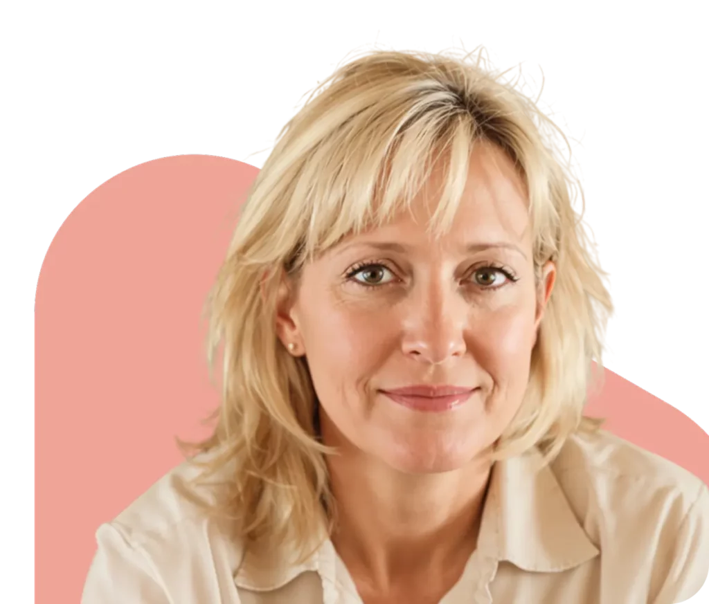 Smiling middle-aged blonde woman with short hair wearing a beige shirt against a soft pink background