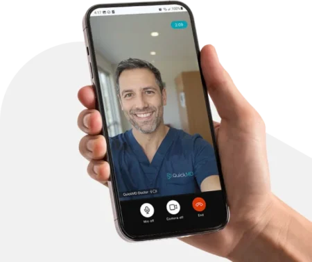 QuickMD online video visit with a smiling male doctor in scrubs