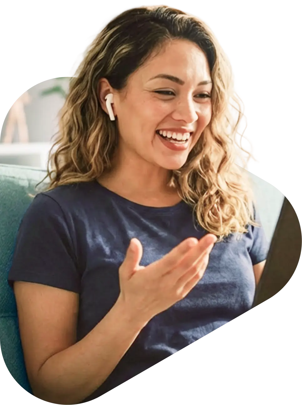Woman smiling and gesturing during a QuickMD telehealth counseling session with wireless earbuds