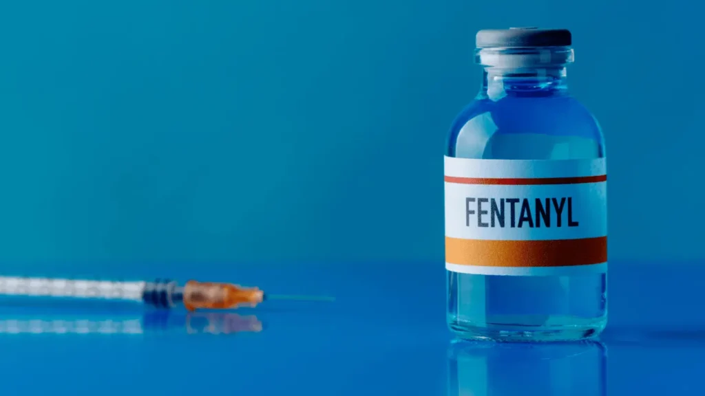 Medical vial labeled “Fentanyl” with syringe on blue background, representing opioid medication and fentanyl crisis awareness