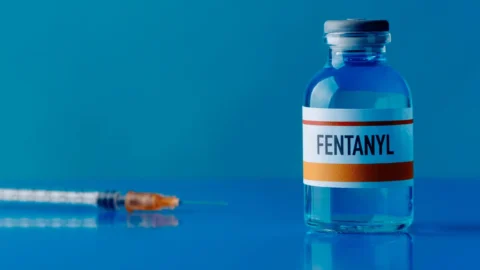 Medical vial labeled “Fentanyl” with syringe on blue background, representing opioid medication and fentanyl crisis awareness