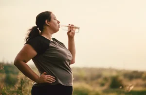 woman--outside-on-a-run-drinking-water