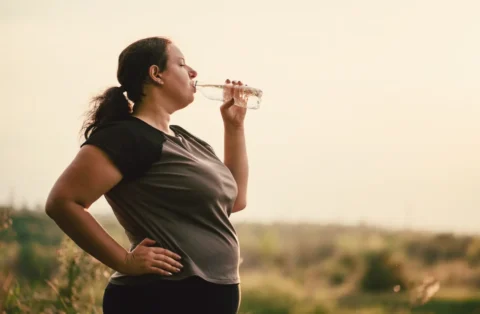 woman--outside-on-a-run-drinking-water
