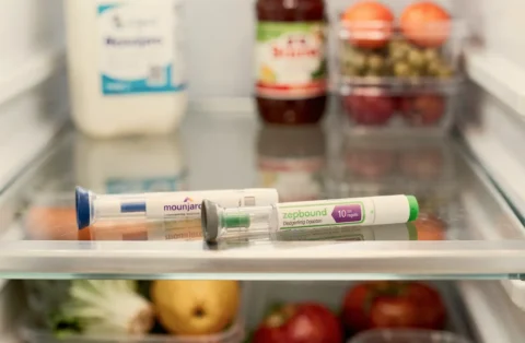 Mounjaro and Zepbound injection pens stored in a refrigerator, representing weight-loss medications prescribed and managed through telehealth care like QuickMD.