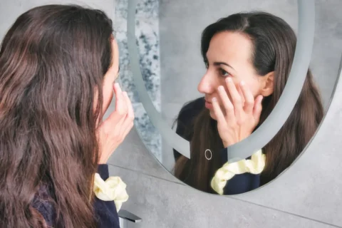 skin-changes-during-perimenopause-and-menopause-woman-looking-at-skin-in-mirror