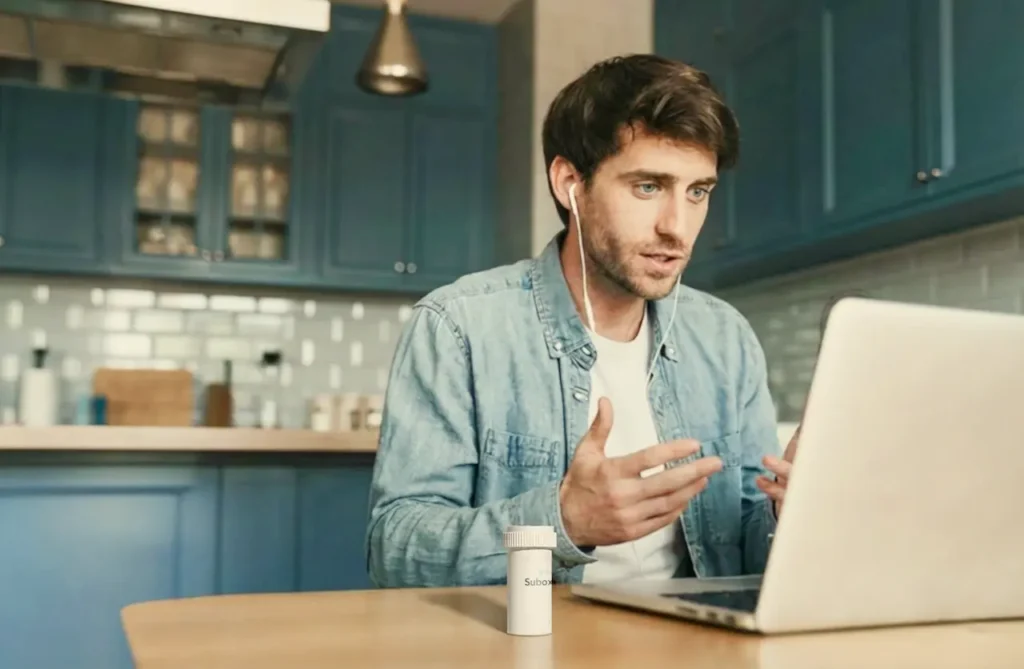 man-on-laptop-speaking-to-doctor-in-kitchen