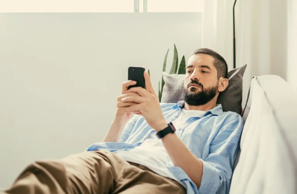 man-sitting-on-couch-doom-scrolling