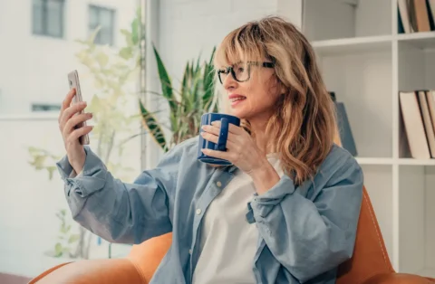 woman-on-phone-with-doctor-holding-coffee-in-hand